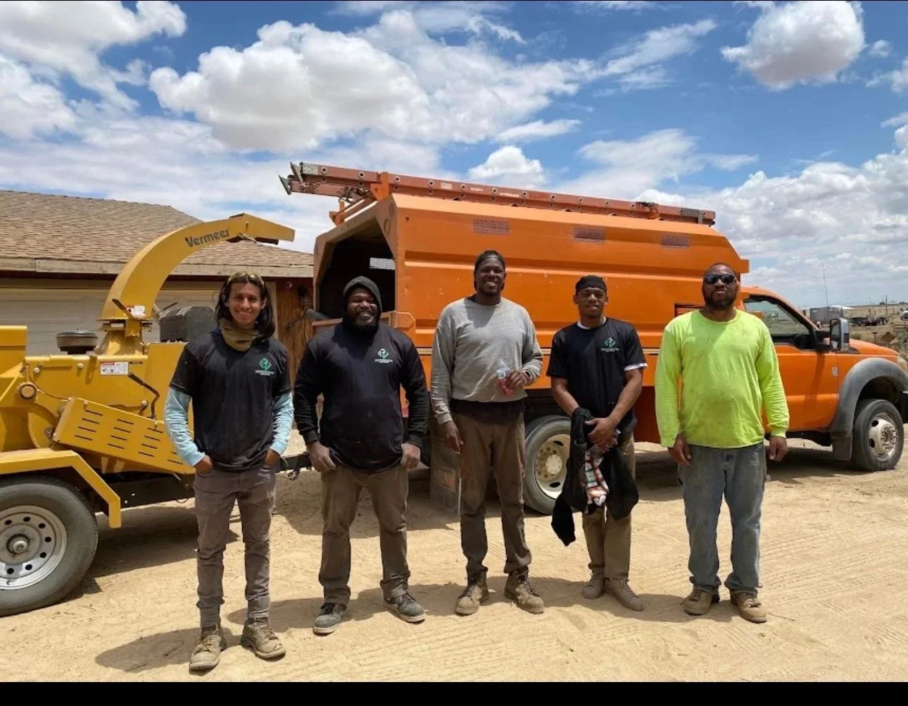 Crew with Vermeer wood chipper and orange dump truck for tree debris removal